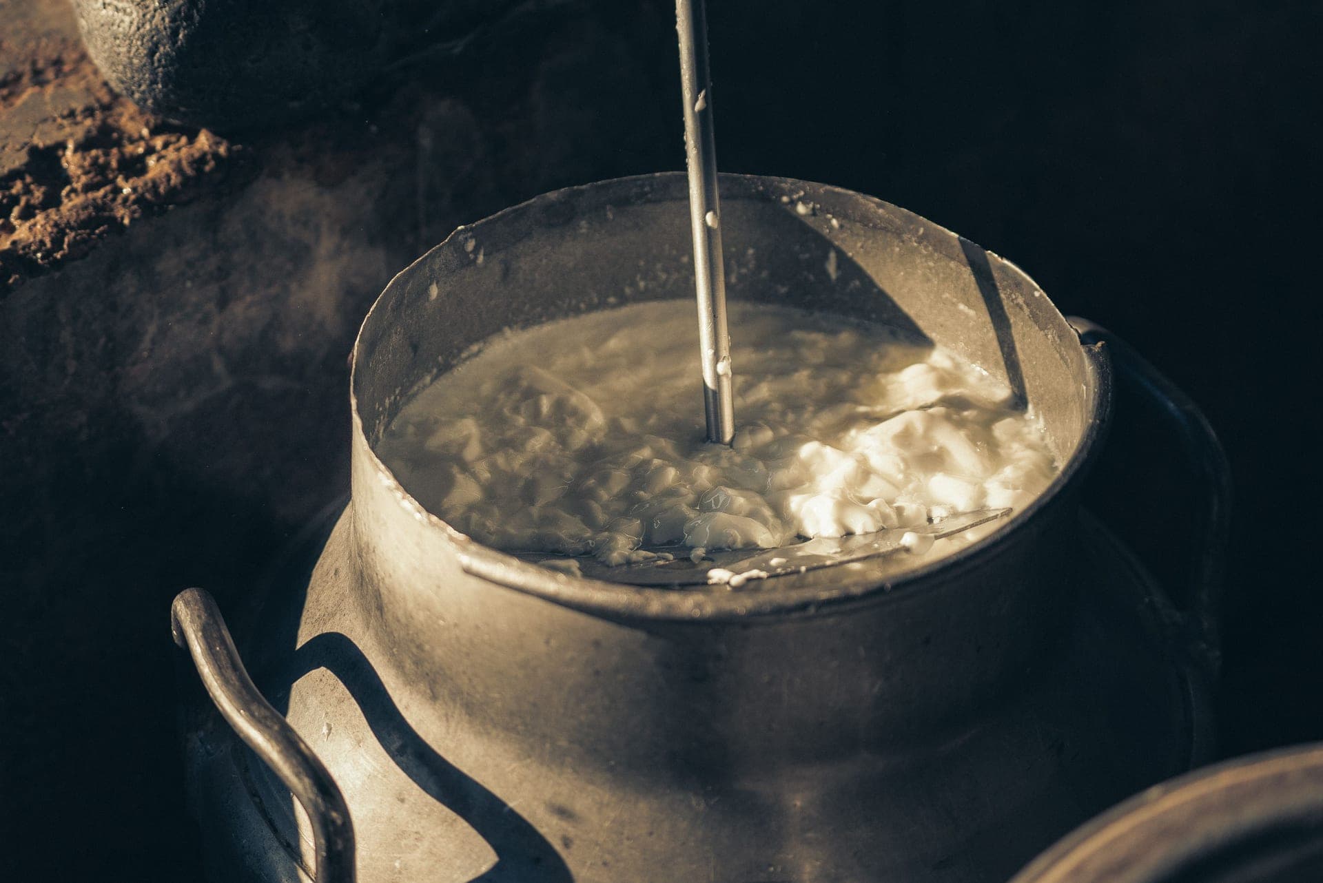 Cream being churned in a vintage metal container