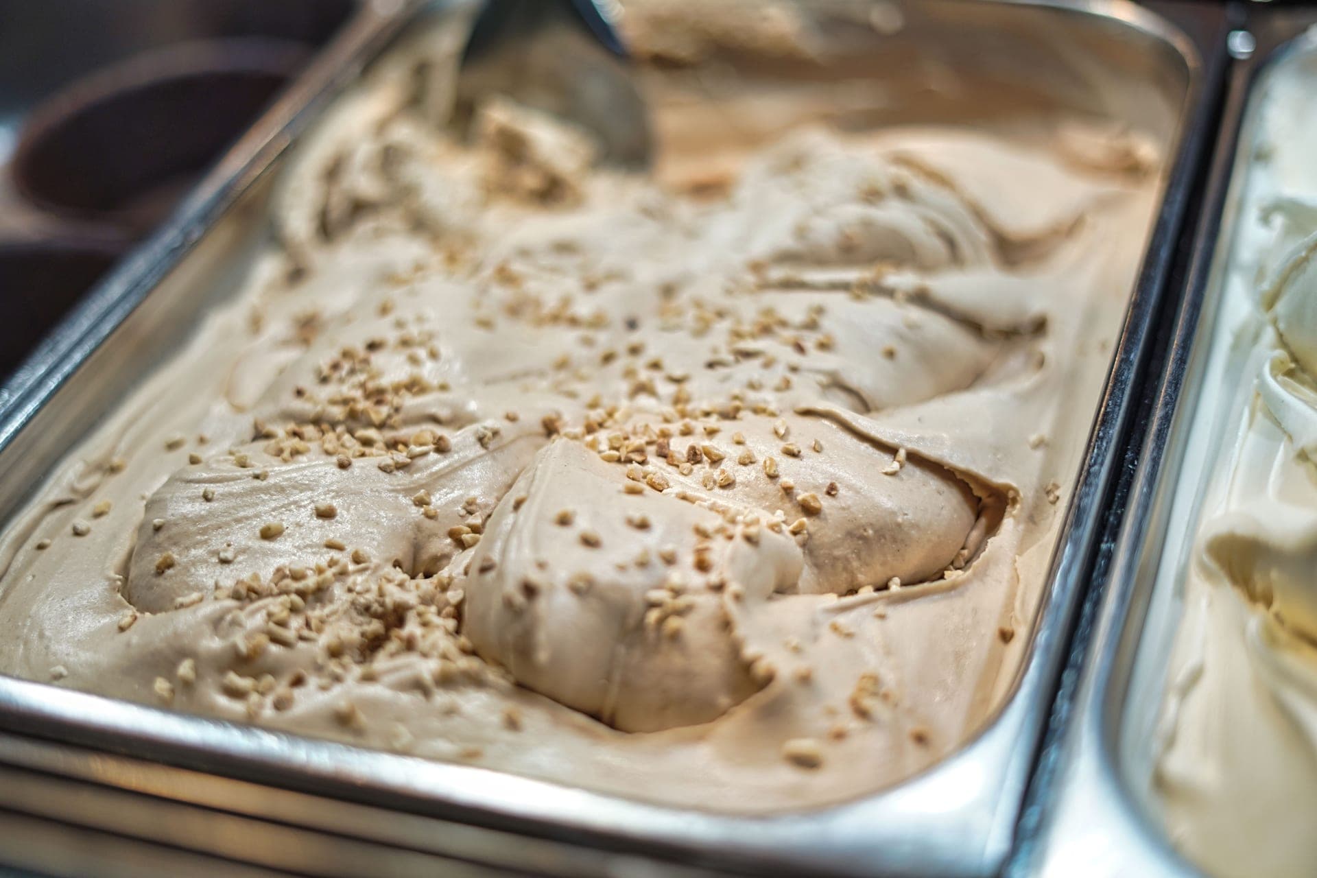 Creamy hazelnut gelato in a metal container, ready to serve